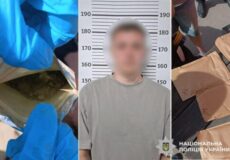 Mugshot of a man in a gray shirt against a height chart, with police presence and seized packages nearby; National Police of Ukraine watermark.