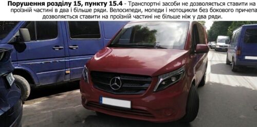 Red Mercedes van parked in a lot between blue vans, front view; Ukrainian warning banner across the top.