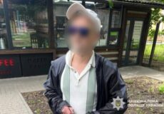 Man wearing a white cap and striped polo shirt, outdoors near a cafe, his face blurred for privacy; police watermark in corner.