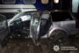 Silver SUV with open doors and visible damage beside a blue train car at night; Ukrainian police watermark