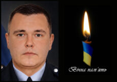 Portrait of a man in a uniform on the left, beside a lit candle with blue-yellow accents and the Ukrainian phrase 'Вічна пам'ять' (eternal memory) on the right, indicating a memorial tribute.