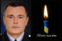 Portrait of a man in a uniform on the left, beside a lit candle with blue-yellow accents and the Ukrainian phrase 'Вічна пам'ять' (eternal memory) on the right, indicating a memorial tribute.