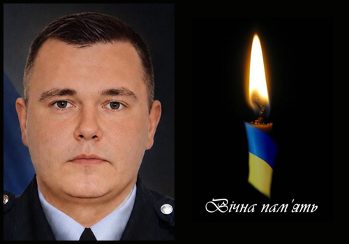 Portrait of a man in a uniform on the left, beside a lit candle with blue-yellow accents and the Ukrainian phrase 'Вічна пам'ять' (eternal memory) on the right, indicating a memorial tribute.