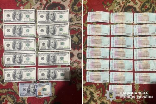 Stacks of US $100 bills on the left and Ukrainian 1000-hryvnia notes on the right on a patterned rug, with a police watermark in the corner.