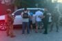 Five men with hands behind their backs are detained by armed officers near a white SUV, with Ukrainian law enforcement logos visible.