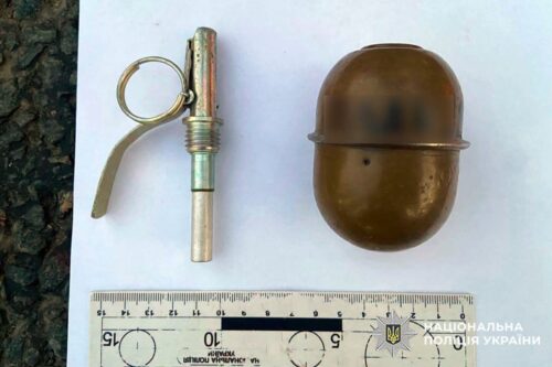 Detonator and a brown explosive grenade shell shown beside a ruler for scale, with police watermark on the image.