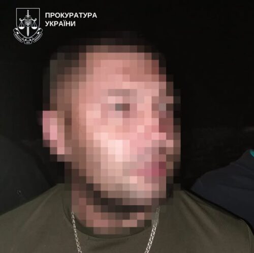 Blurry side-profile of a man wearing a green shirt and chain; Ukrainian prosecutorate watermark in the corner.