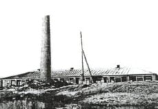 Old industrial building with a tall smokestack on a rocky hill, in a black-and-white landscape sketch.