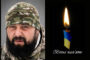 Left: a bearded man in camouflage gear; right: a lit candle with a blue-yellow ribbon and the Ukrainian phrase 'Вічна пам'ять' meaning Eternal memory, a memorial image.