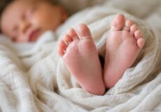 Close-up of a sleeping baby's feet wrapped in a soft blanket.
