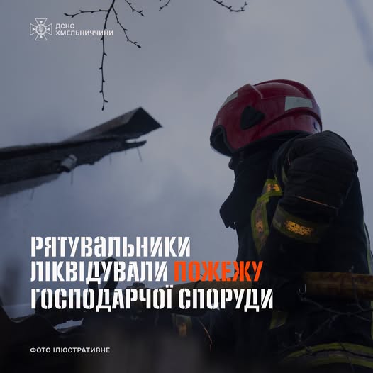 Firefighter in a red helmet beside a burned wooden outbuilding; overlaid headline: 'Рятувальники ліквідували пожежу господарчої споруди'.
