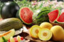 Assorted fresh fruit on a table: whole and sliced watermelons, cantaloupe pieces, and yellow melons among other bite-sized fruit.