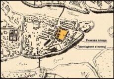 Historic map of a town showing a prison complex; a yellow-highlighted building near the market square and prison premises along a river.