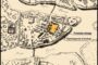 Historic map of a town showing a prison complex; a yellow-highlighted building near the market square and prison premises along a river.
