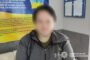 Person with blurred face sits in a police interview room; Ukrainian flag banner and police watermark are visible in the background.