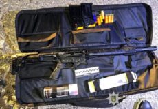 Open rifle case displaying a long gun with magazines, ammunition, and cleaning supplies arranged inside