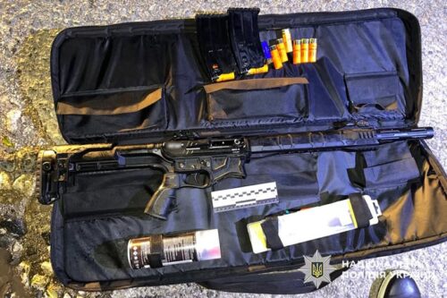Open rifle case displaying a long gun with magazines, ammunition, and cleaning supplies arranged inside
